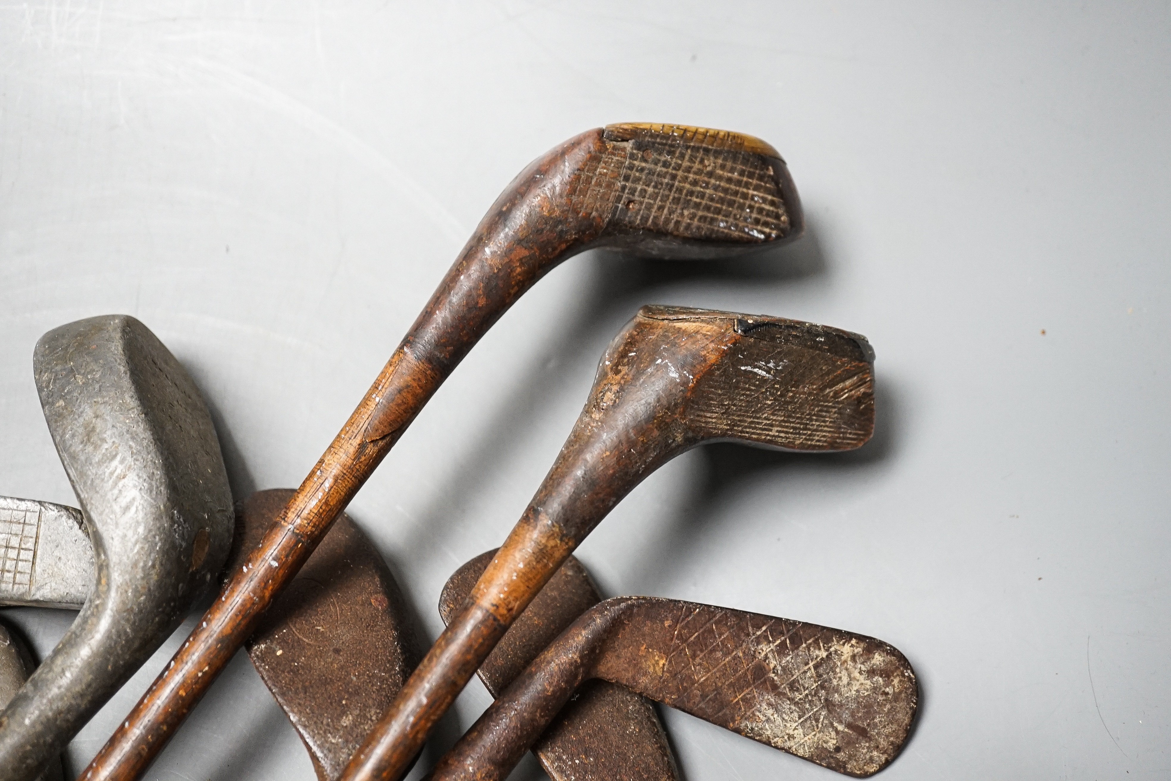 Golf clubs, knobkerrie in a leather carrier, carrier 50cms high.